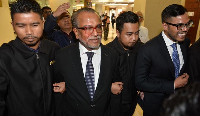 Muhammad Shafee Abdullah, second left, arrives at the High Court for a hearing in Kuala Lumpur, Malaysia, Thursday, Sept. 13, 2018. Shafee, a top lawyer for former Prime Minister Najib Razak has been charged in court with receiving 9.5 million ringgit ($2.3 million) from Najib believed to have come from billions laundered from a state investment fund. (AP Photo)