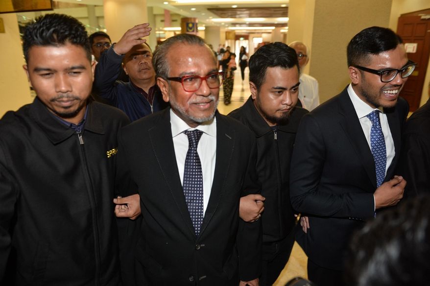 Muhammad Shafee Abdullah, second left, arrives at the High Court for a hearing in Kuala Lumpur, Malaysia, Thursday, Sept. 13, 2018. Shafee, a top lawyer for former Prime Minister Najib Razak has been charged in court with receiving 9.5 million ringgit ($2.3 million) from Najib believed to have come from billions laundered from a state investment fund. (AP Photo)