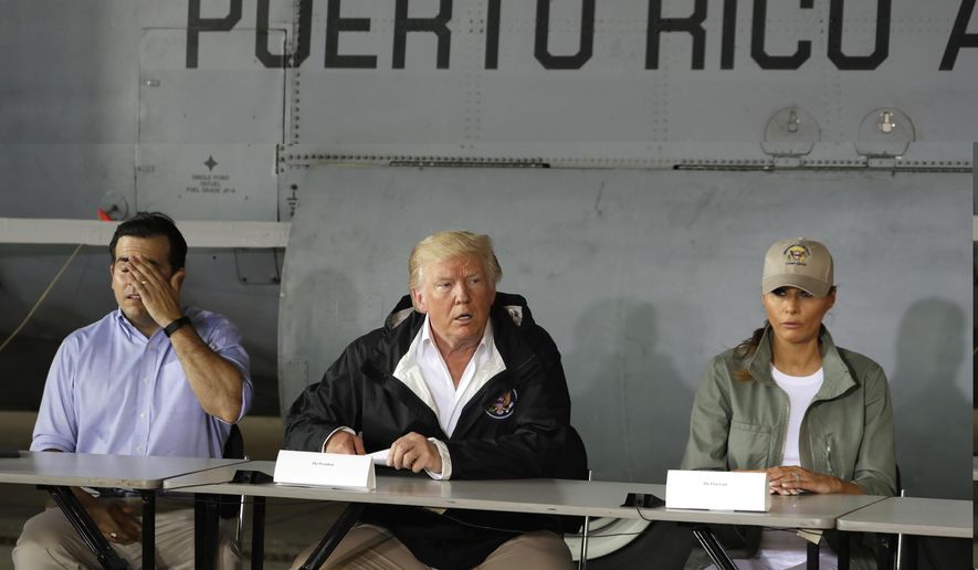 In this Oct. 3, 2017, file photo, President Donald Trump talks about recovery efforts after he and first lady Melania Trump arrived at Luis Muniz Air National Guard Base to survey hurricane damage in San Juan, Puerto Rico, as Puerto Rico Gov. Ricardo Rosselló, left, listens. (AP Photo/Evan Vucci, File)
