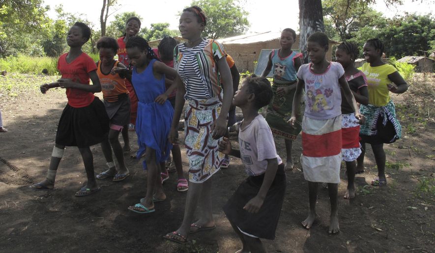 In this photo taken Friday, April 20, 2018 in the Gorongosa National Park, Mozambique, Mozambican girls dance as part of a girls' club program that aims to help girls stay in school longer and stay out of child marriage, a longstanding problem in the southern African country. About 50 girls clubs have been set up by the managers of Gorongosa National Park, who believe that human development and conservation go hand in hand. (AP Photo/Christopher Torchia)