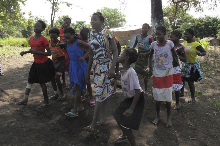 In this photo taken Friday, April 20, 2018 in the Gorongosa National Park, Mozambique, Mozambican girls dance as part of a girls' club program that aims to help girls stay in school longer and stay out of child marriage, a longstanding problem in the southern African country. About 50 girls clubs have been set up by the managers of Gorongosa National Park, who believe that human development and conservation go hand in hand. (AP Photo/Christopher Torchia)