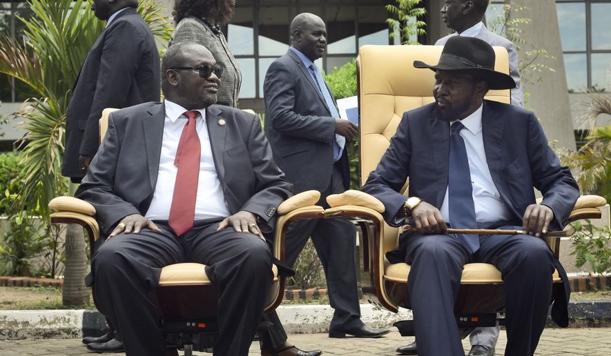 FILE - In this Friday, April 29, 2016 file photo, South Sudan's then First Vice President Riek Machar, left, looks across at President Salva Kiir, right, as the two sit to be photographed following the first meeting of a new transitional coalition government, in the capital Juba, South Sudan. South Sudan's warring parties on Wednesday, Sept. 12, 2018, signed what they say is the final peace agreement to end the country's five-year civil war, which has killed tens of thousands and displaced millions. (AP Photo/Jason Patinkin, File)