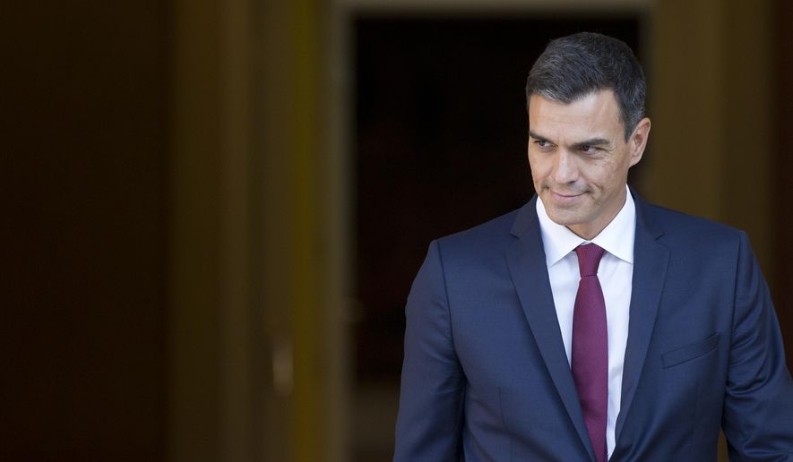 Spain's Prime Minister Pedro Sanchez steps out of the Moncloa Palace in Madrid, Spain, Wednesday, Sept. 12, 2018. Sanchez, who became prime minister in June promising to root out corruption, lost a culture minister over a tax fine and Spain's health minister resigned Tuesday over irregularities found in her master's degree. His center-left government has been marred by erratic policy-making, with several U-turns on cabinet decisions. (AP Photo/Paul White)