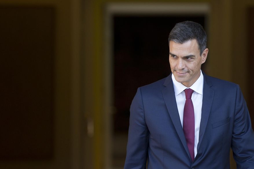 Spain's Prime Minister Pedro Sanchez steps out of the Moncloa Palace in Madrid, Spain, Wednesday, Sept. 12, 2018. Sanchez, who became prime minister in June promising to root out corruption, lost a culture minister over a tax fine and Spain's health minister resigned Tuesday over irregularities found in her master's degree. His center-left government has been marred by erratic policy-making, with several U-turns on cabinet decisions. (AP Photo/Paul White)