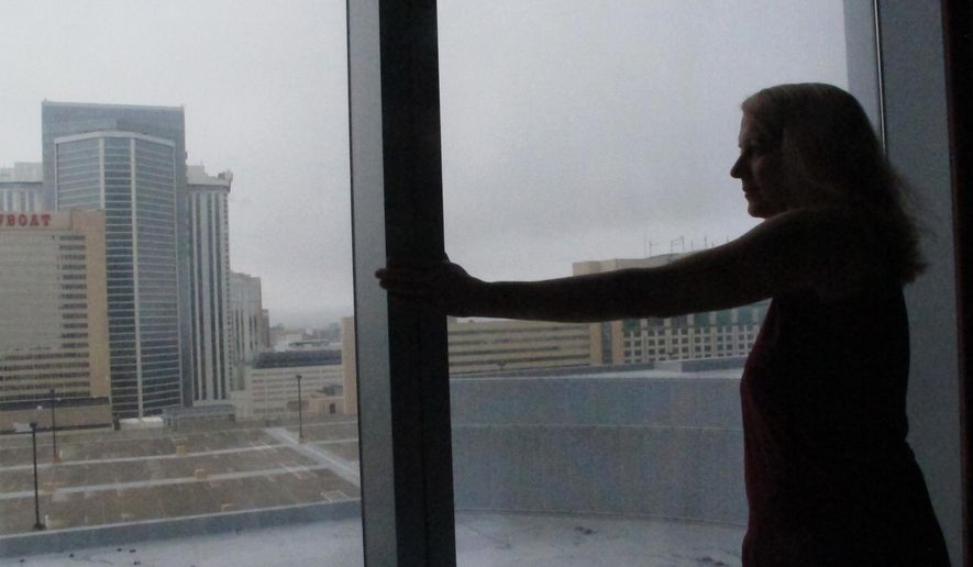 Mimi Razzi of Pawleys Island, S.C. looks out the window from her room at the Ocean Resort Casino in Atlantic City N.J. on Friday Sept. 14, 2018. Razzi was one of hundreds of people fleeing Hurricane Florence who accepted the casino's offer of free lodging until the storm had passed. (AP Photo/Wayne Parry)