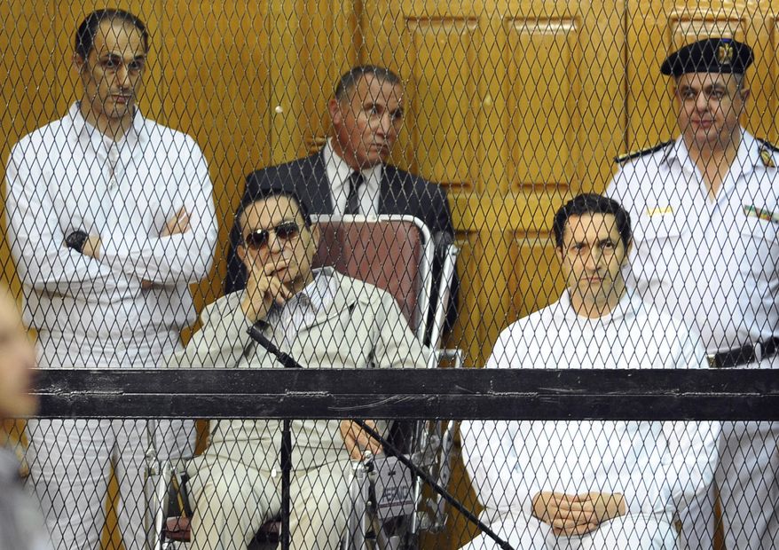 FILE - In this Sept. 14, 2013 file photo, former Egyptian President Hosni Mubarak, seated center left, and his two sons, Gamal Mubarak, left, and Alaa Mubarak attend a hearing in a courtroom in Cairo, Egypt.  Egyptian officials say police have detained the sons of former president Hosni Mubarak in connection with inside trading charges. They said the arrests were ordered Saturday, Sept. 15, 2018 by judge Ahmed Aboul-Fetouh before he adjourned the hearings to October 20. (AP Photo/Mohammed al-Law, File)