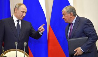 In this file photo taken on Wednesday, May 12, 2018, Russian President Vladimir Putin, left, speaks with Igor Sechin, CEO of Russian oil giant Rosneft, at a joint news conference with Italian Prime Minister Paolo Gentiloni at the Bocharov Ruchei state residence in Russian Black Sea resort of Sochi, Russia. Experts say President Vladimir Putin isn’t necessarily dictating every Russian influence campaign abroad. Some accused of meddling in the 2016 U.S. elections appear to be ambitious individuals taking the initiative based on signals from the presidential entourage. (Yuri Kadobnov/ Pool photo via AP, File)