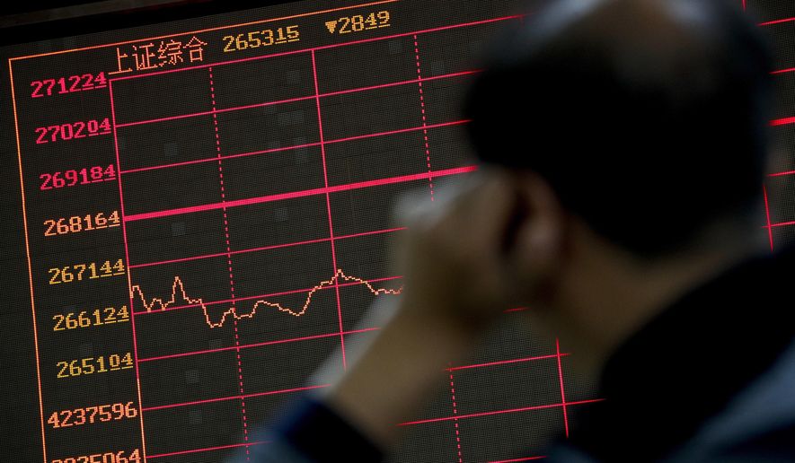 An investor monitors shares prices in front of an electronic board displaying the Shanghai Composite index at a brokerage house in Beijing, Monday, Sept. 17, 2018. Asian shares were mostly lower Monday on reports that President Donald Trump will soon place tariffs on $200 billion more of Chinese goods, even as officials worked to iron out tensions between the world's two largest economies. (AP Photo/Andy Wong)