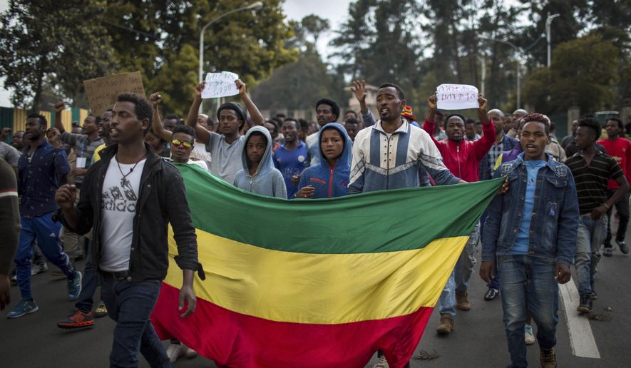 Thousands of protestors from the capital and those displaced by ethnic-based violence over the weekend in Burayu, demonstrate to demand justice from the government in Addis Ababa, Ethiopia Monday, Sept. 17, 2018. Several thousand Ethiopians have gone out onto the streets of the capital to protest ethnic-based attacks in the outskirts of the city in which more than 20 people died over the weekend. Three banners in Amharic from left to right read "Justice for the people of Amhara, Tigray and Southerners", "Stop ethnic-based attacks" and "One mouth, but two tongues". (AP Photo/Mulugeta Ayene)