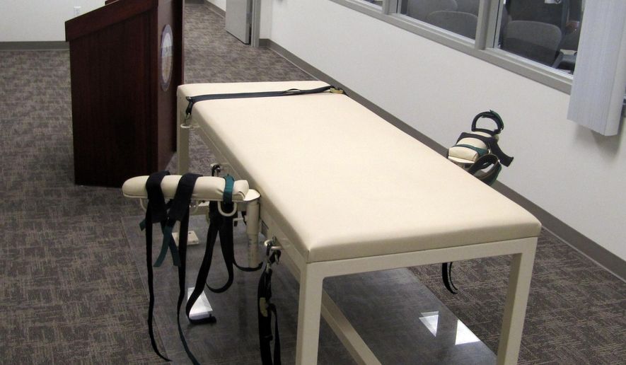 FILE - This Oct. 20, 2011 file photo shows the execution chamber at the Idaho Maximum Security Institution as Warden Randy Blades, right, stands in the observation room, in Boise, Idaho. An Idaho judge now says state prison officials can hold off on identifying where they obtain the drugs used in executions until a trial is held on the matter. (AP Photo/Jessie L. Bonner, File)