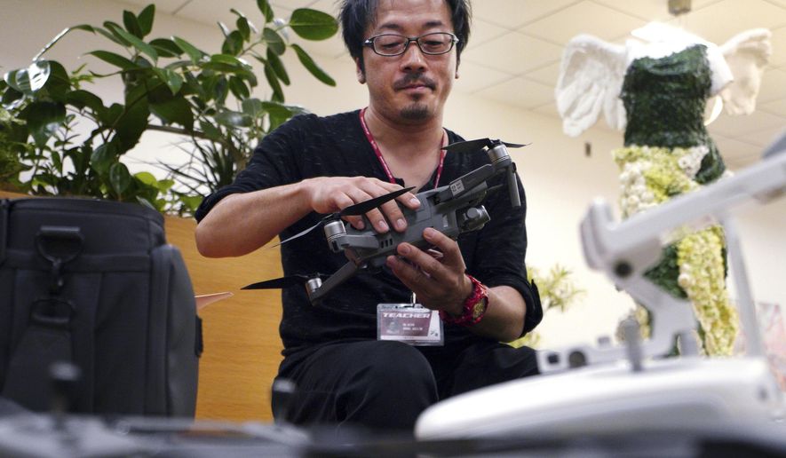 In this Sept. 13, 2018 photo, Atsushi Taguchi, a &amp;quot;drone grapher,&amp;quot; as those specializing in drone video are called, who teaches at Tokyo film school Digital Hollywood, speaks during an interview with the Associated Press in Tokyo. Taguchi acknowledged flying cars won’t become a reality for years, but test flights in limited areas, such as an airport, will likely be carried out sooner. (AP Photo/Eugene Hoshiko)