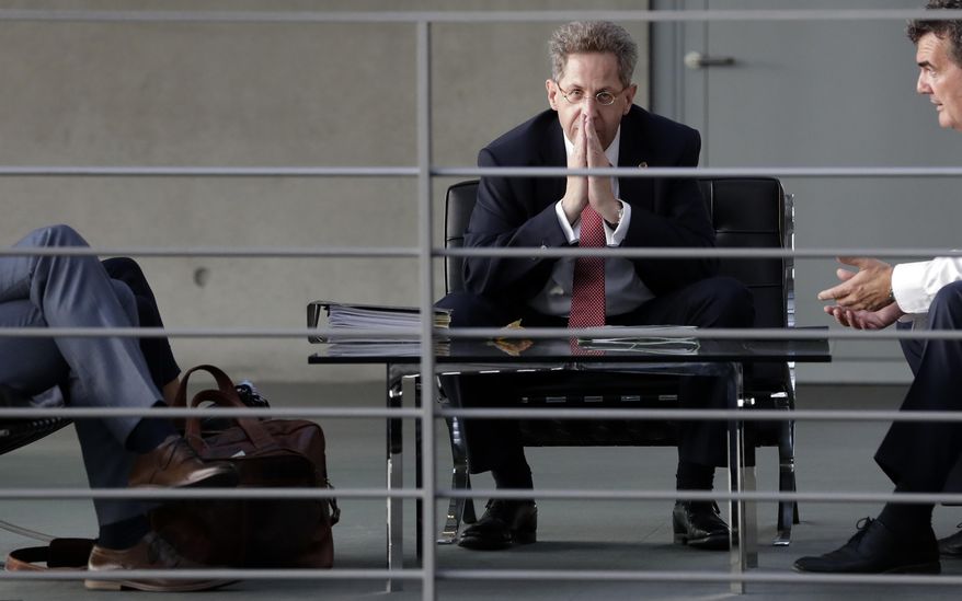 FILE-- In this Wednesday, Sept. 12, 2018 photo Hans-Georg Maassen, center, head of the German Federal Office for the Protection of the Constitution, waits for the beginning of a hearing at the home affairs committee of the German federal parliament, Bundestag, in Berlin, Germany. The leaders of Germany&#39;s three governing parties are meeting in Berlin on Tuesday to decide the fate of the country&#39;s domestic intelligence chief amid calls for him to be fired over his approach to far-right extremism. (AP Photo/Michael Sohn, file)