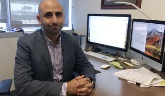 Dr. Fatta Nahab, a neurologist who directs the Functional Imaging of Neurodegenerative Disorders Lab at the University of California San Diego Health&#39;s Movement Disorder Center, sits at his desk Monday, Sept 17, 2018, in San Diego. Nahab spent years going through regulatory hoops to get approval to import marijuana from Canada, to study whether cannabis can help treat essential tremor, a shaking condition affecting millions of people. (AP Photo/Julie Watson)