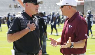 FILE - In this Sept. 23, 2017, file photo, Old Dominion head coach Bobby Wilder, left, greets Virginia Tech head coach Justin Fuente prior to the start of an NCAA college football game in Blacksburg, Va. Bobby Wilder and the Monarchs are excited about their rare opportunity to host at Top 25 program. No. 13 Virginia Tech makes the instate trek to the Tidewater area on Saturday. (AP Photo/Steve Helber, File)