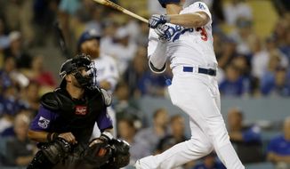 Los Angeles Dodgers&#39; Joc Pederson, right, follows though on his two-RBI home run with Colorado Rockies catcher Drew Butera watching during the fourth inning of a baseball game in Los Angeles, Monday, Sept. 17, 2018. (AP Photo/Alex Gallardo)
