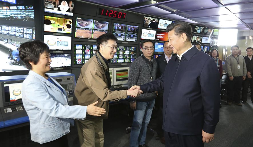FILE - In this Feb. 19, 2016, file photo released by China's Xinhua News Agency, Chinese President Xi Jinping, right, shakes hands with staff members at the control room of China Central Television (CCTV) in Beijing. China said Wednesday, Sept. 19, 2018, that it has reached out to the U.S. over reports that the Department of Justice has ordered Chinese state-run media outlets, Xinhua News Agency and CGTN, the international arm of state broadcaster CCTV, to register with the government as foreign agents. (Ma Zhancheng/Xinhua via AP, File)