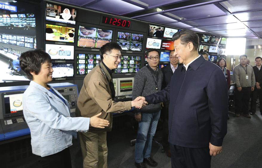 FILE - In this Feb. 19, 2016, file photo released by China's Xinhua News Agency, Chinese President Xi Jinping, right, shakes hands with staff members at the control room of China Central Television (CCTV) in Beijing. China said Wednesday, Sept. 19, 2018, that it has reached out to the U.S. over reports that the Department of Justice has ordered Chinese state-run media outlets, Xinhua News Agency and CGTN, the international arm of state broadcaster CCTV, to register with the government as foreign agents. (Ma Zhancheng/Xinhua via AP, File)