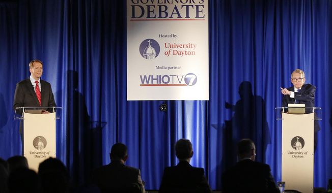 Gubernatorial candidates, Republican Mike DeWine, right, and his opponent Democrat Richard Cordray, left, speak during a debate at the University of Dayton on Wednesday, Sept. 19, 2018, in Dayton, Ohio. Future debates are scheduled for Oct. 1 in Marietta and Oct. 8 in Cleveland ahead of the November election. (Ty Greenless/Dayton Daily News via AP)