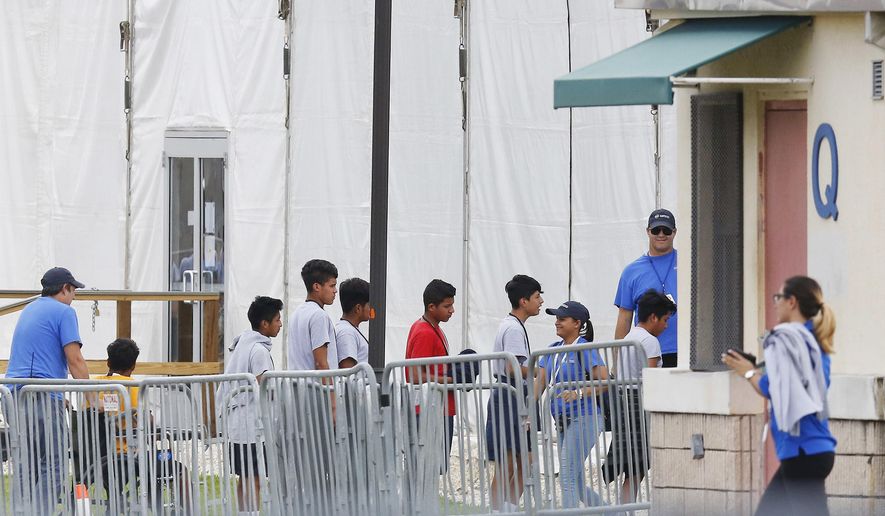FILE - In this June 20, 2018, file photo, Immigrant children walk in a line outside the Homestead Temporary Shelter for Unaccompanied Children a former Job Corps site that now houses them in Homestead, Fla. A Senate subcommittee has found that federal officials for the second time lost track of nearly 1,500 migrant children earlier this year after a government agency placed the minors in the custody of adult sponsors in communities nationwide. (AP Photo/Brynn Anderson, File)