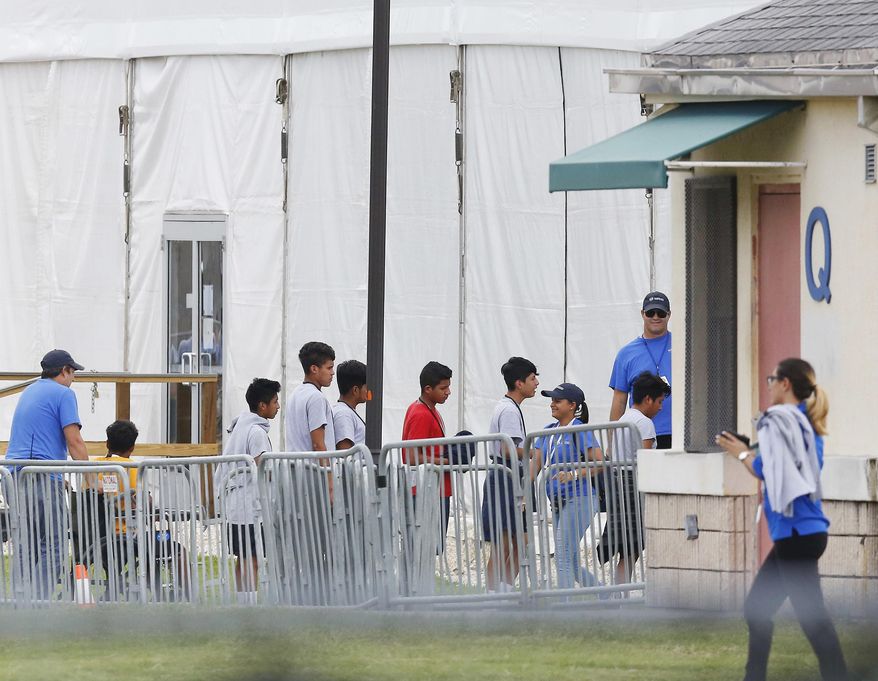 FILE - In this June 20, 2018, file photo, Immigrant children walk in a line outside the Homestead Temporary Shelter for Unaccompanied Children a former Job Corps site that now houses them in Homestead, Fla. A Senate subcommittee has found that federal officials for the second time lost track of nearly 1,500 migrant children earlier this year after a government agency placed the minors in the custody of adult sponsors in communities nationwide. (AP Photo/Brynn Anderson, File)