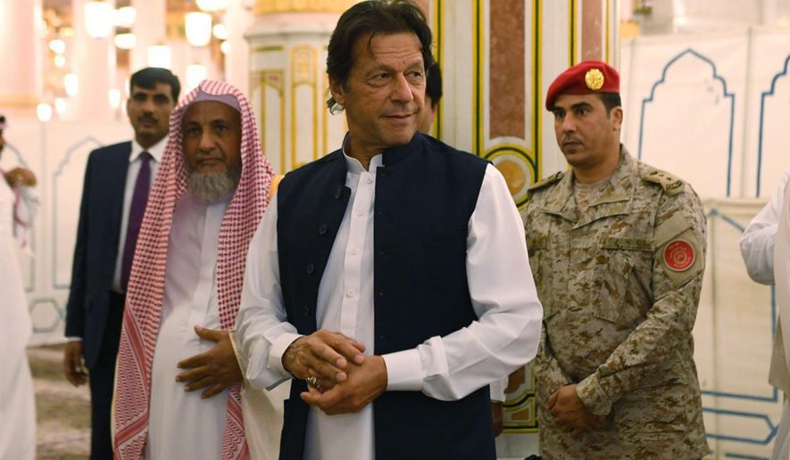In this Tuesday, Sept. 18, 2018, photo released by the state-run Saudi Press Agency, Pakistani Prime Minister Imran Khan, center, visits the Prophet&#x27;s Mosque in Medina, Saudi Arabia. Khan, a former cricketer, is on a tour of Saudi Arabia and the United Arab Emirates as part of his first overseas trip since taking office. (Saudi Press Agency via AP)