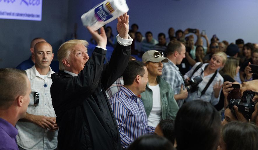 FILE - In this Oct. 3, 2017 file photo, President Donald Trump tosses paper towels into a crowd at Calvary Chapel in Guaynabo, Puerto Rico. (AP Photo/Evan Vucci, File)