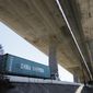 In this July 2, 2018, file photo, a truck carrying a cargo container drives under the Gerald Desmond Bridge under construction in Long Beach, Calif. China on Tuesday, Sept. 18, 2018, announced a tariff hike on $60 billion of U.S. products in response to President Donald Trump&#39;s latest duty increase in a dispute over Beijing&#39;s technology policy. (AP Photo/Jae C. Hong, File)