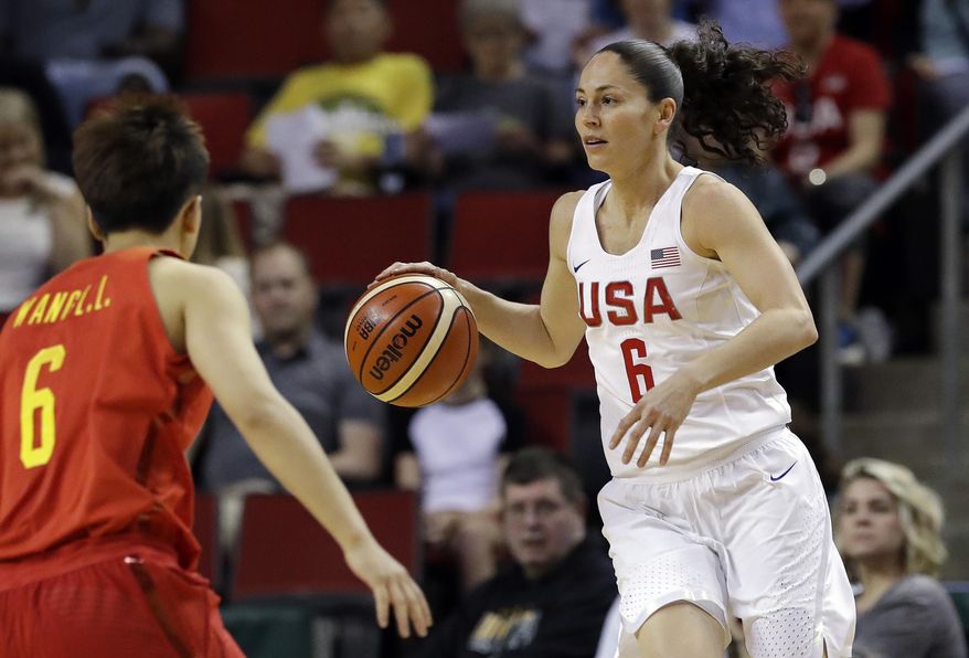 FILE - In this April 26, 2018, file photo, United States' Sue Bird, right, dribbles as China's Lili Wang defends during the first half of an exhibition basketball game in Seattle. Bird is on a record fifth U.S. women's basketball World Cup team. The veteran guard will try and help the Americans win a third straight FIBA Women's Basketball World Cup title and in the process her unprecedented fourth gold medal in the tournament. (AP Photo/Elaine Thompson, File)