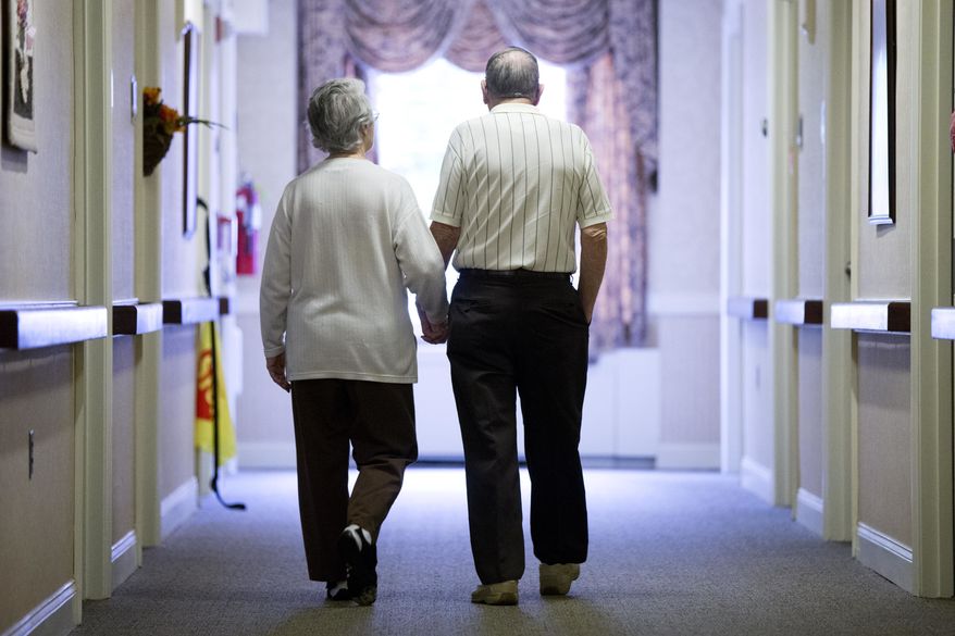 In this Nov. 6, 2015, photo, an elderly couple walks down a hall in Easton, Pa. It's not too late to get moving: Simple physical activity, mostly walking, helped high-risk seniors stay mobile after disability-inducing ailments even if, at 70 and beyond, they'd long been couch potatoes. (AP Photo/Matt Rourke) **FILE**