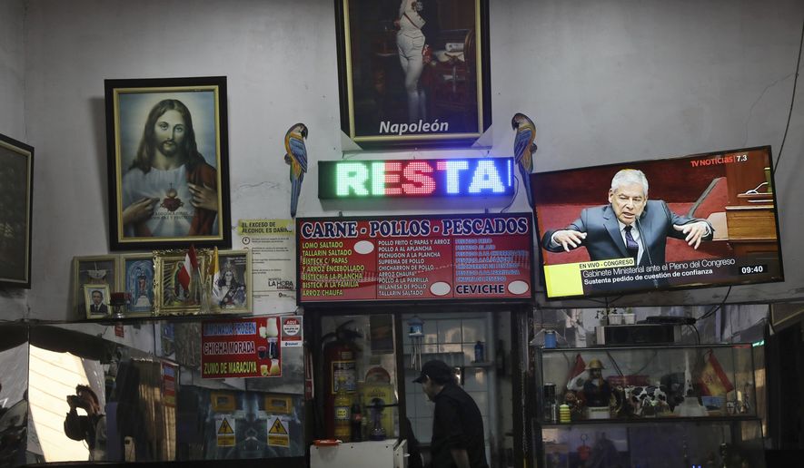 A television screen in the Napoleon restaurant shows Peru's Prime Minister Cesar Villanueva speaking, right, in the Legislative Palace chamber where lawmakers are debating President Martin Vizcarra's call for a referendum on anti-corruption measures, in Lima, Peru, Wednesday, Sept. 19, 2018. If Congress refuses to back his plan, Vizcarra will be empowered to dissolve the legislature, something that hasn't happened since the authoritarian government of Alberto Fujimori in 1992. (AP Photo/Rodrigo Abd)