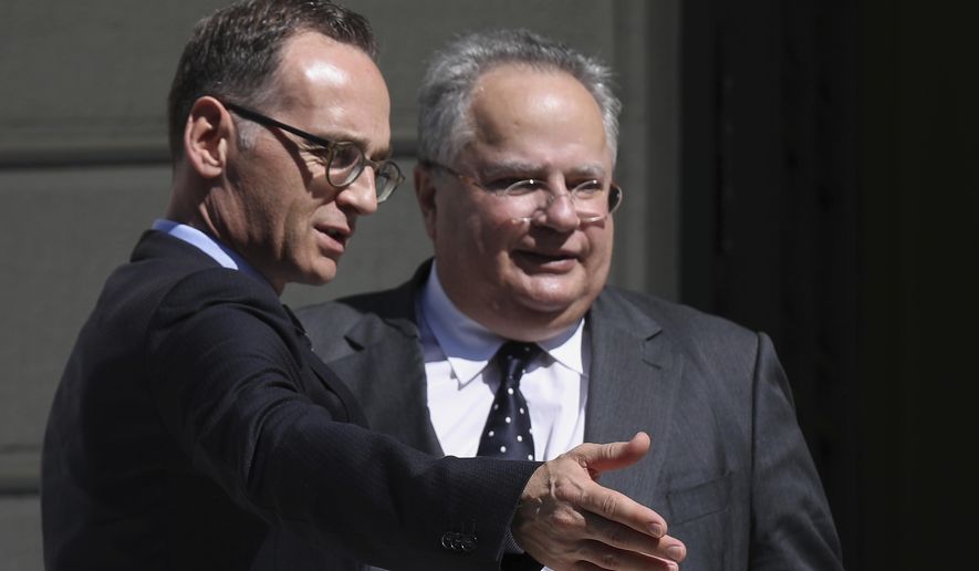 Greek Foreign Minister Nikos Kotzias, right, welcomes his German counterpart Heiko Maas prior their talks in Athens on, Thursday, Sept. 20, 2018. (AP Photo/Petros Giannakouris)