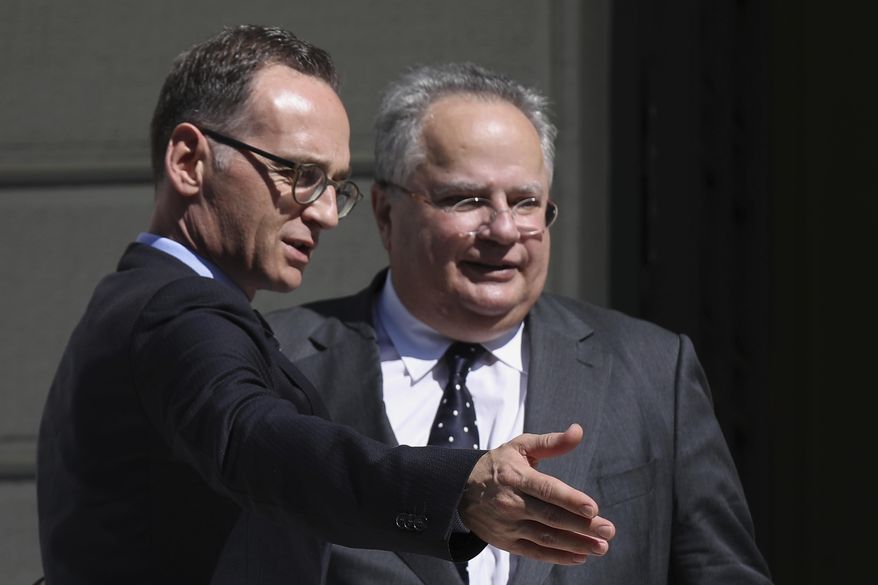 Greek Foreign Minister Nikos Kotzias, right, welcomes his German counterpart Heiko Maas prior their talks in Athens on, Thursday, Sept. 20, 2018. (AP Photo/Petros Giannakouris)