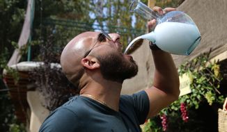 In this Saturday Sept. 8, 2018 photo, a Lebanese man drinks arak from a traditional glass pitcher during a festival that celebrates Lebanon&#39;s national alcoholic drink, in the town of Taanayel, east Lebanon. The anise-tinged arak, is surrounded by ritual -- from its distilling down to the moment when it’s mixed, turning milky white in water, and drunk over long, lingering meals. (AP Photo/Hussein Malla)