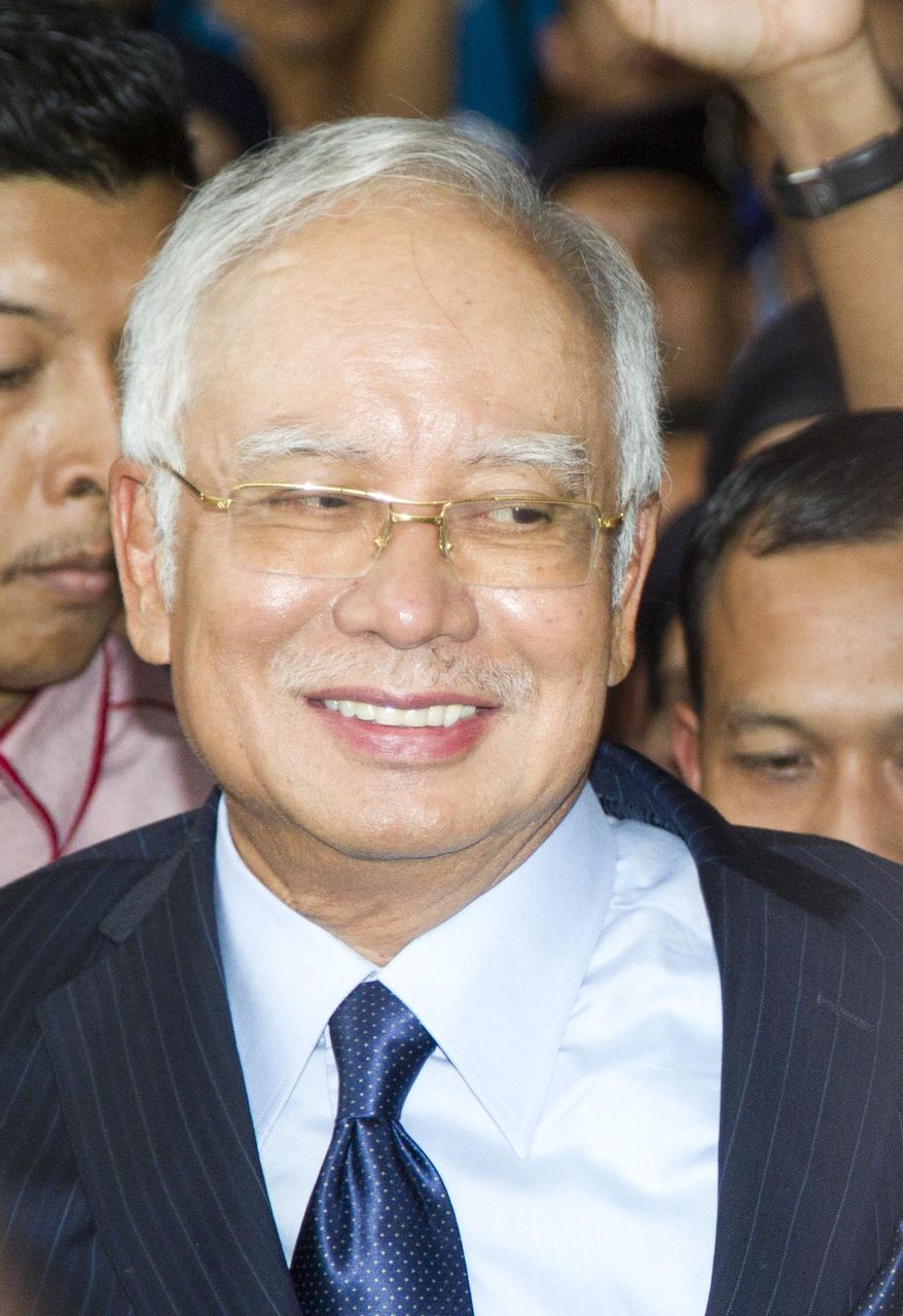 Former Prime Minister Najib Razak smiles as he walks out of Kuala Lumpur High Court after a court hearing in Kuala Lumpur, Malaysia, Thursday, Sept. 20, 2018. Najib remained defiant, saying the fresh 25 charges against him will give him a chance to clear his name. (AP Photo/Yam G-Jun)