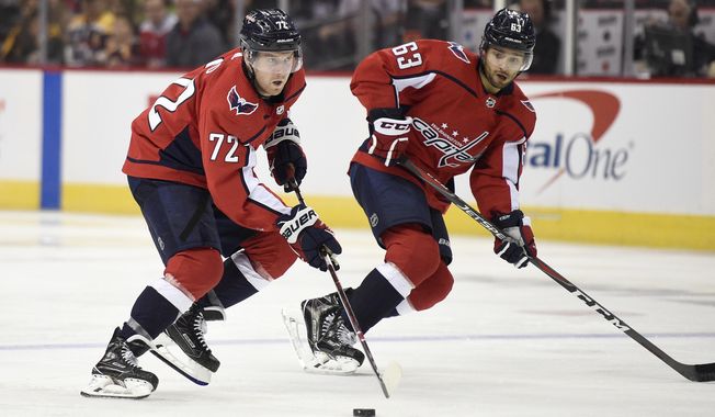 Washington Capitals center Travis Boyd (72) skates with the puck next to left wing Shane Gersich (63) during the third period of an NHL preseason hockey game against the Boston Bruins, Tuesday, Sept. 18, 2018, in Washington. The Bruins won 5-2. (AP Photo/Nick Wass) ** FILE **