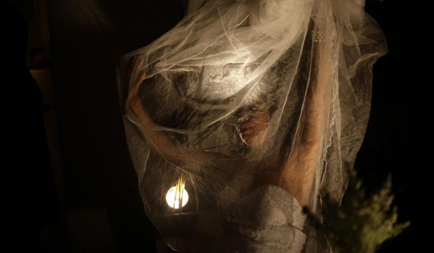 In this Aug. 26, 2018 photo, domestic violence survivor Rogeria Cardeal prepares for her theater performance as a bride about to marry her aggressor, in a play coined “Hidden Enemies," in Rio de Janeiro, Brazil. Cardeal said the spectators may come to understand and recognize domestic violence in their own lives. (AP Photo/Beatrice Christofaro)