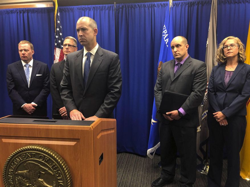 U.S. Attorney John Anderson, center at podium, speaks about the investigation into a fugitive Catholic priest who is accused of sex abuse at a news conference Friday, Sept. 21, 2018, in Albuquerque, N.M. Federal authorities said FBI agents returned 80-year-old Arthur Perrault to New Mexico on Friday to face child sexual abuse charges after a year in the custody of Moroccan authorities. (AP Photo/Mary Hudetz)