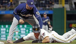Milwaukee Brewers third baseman Mike Moustakas tags out Pittsburgh Pirates&#39; Jordan Luplow diving back to third base after attempting to steal home in the eighth inning of a baseball game in Pittsburgh, Saturday, Sept. 22, 2018. The Pirate won 3-0. (AP Photo/Gene J. Puskar)