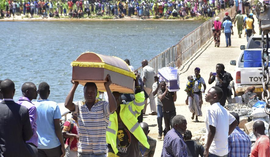 Relatives carry coffins to be used for the victims of the MV Nyerere passenger ferry on Ukara Island, Tanzania Saturday, Sept. 22, 2018. The death toll soared past 200 on Saturday while officials said a survivor was found inside the capsized ferry and search efforts were ending to focus on identifying bodies, two days after the Lake Victoria disaster. (AP Photo/Andrew Kasuku)