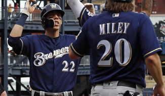 Milwaukee Brewers&#39; Christian Yelich (22) is greeted by Wade Miley (20) as he crosses home plate after hitting a three-run home run off Pittsburgh Pirates starting pitcher Nick Kingham, left, in the third inning of a baseball game in Pittsburgh, Sunday, Sept. 23, 2018. (AP Photo/Gene J. Puskar)