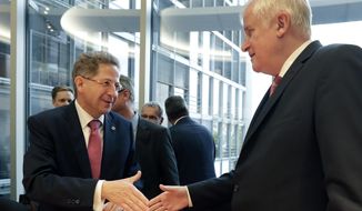 FILE -- In this Wednesday, Sept. 12, 2018 photo Hans-Georg Maassen, left, head of the German Federal Office for the Protection of the Constitution, and German Interior Minister Horst Seehofer, right, shake hands as they arrive for a hearing at the home affairs committee of the German federal parliament, Bundestag, in Berlin, Germany. The leaders of German Chancellor Angela Merkel&#39;s governing coalition were trying Sunday to resolve a standoff over the future of the country&#39;s domestic intelligence chief and stabilize their six-month-old alliance. (AP Photo/Michael Sohn)
