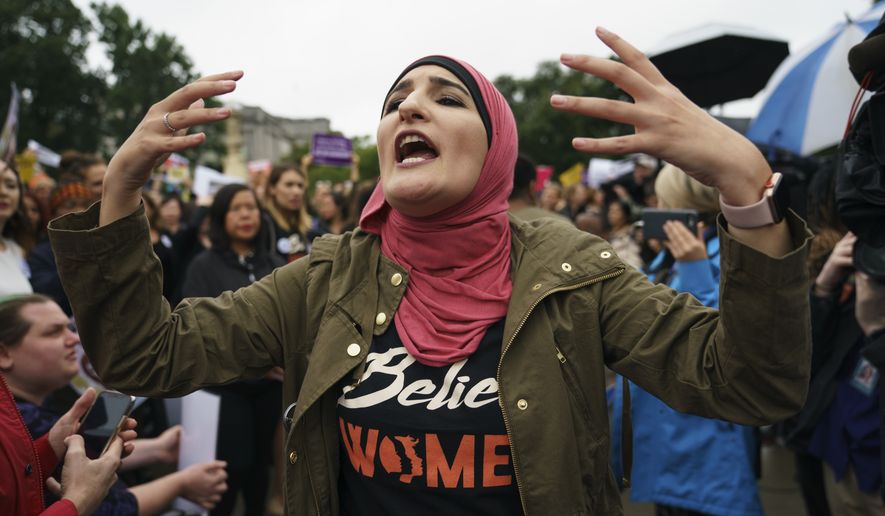 Linda Sarsour with Women's March calls out to other activists opposed to President Donald Trump's embattled Supreme Court nominee, Brett Kavanaugh, in front of the Supreme Court on Capitol Hill in Washington, Monday, Sept. 24, 2018. A second allegation of sexual misconduct has emerged against Judge Brett Kavanaugh, a development that has further imperiled his nomination to the Supreme Court, forced the White House and Senate Republicans onto the defensive and fueled calls from Democrats to postpone further action on his confirmation. President Donald Trump is so far standing by his nominee. (AP Photo/Carolyn Kaster)