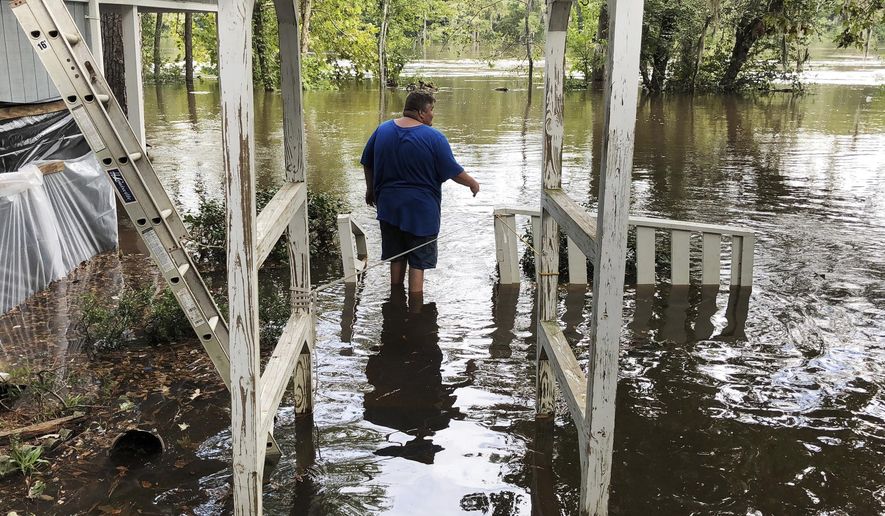 Shawn Lowrimore, son of Pastor Willie Lowrimore of The Fellowship With Jesus Ministries, wades into water near the church in Yauhannah, S.C., on Monday, Sept. 24, 2018. The church is on the bank of the Waccamaw River, which has already risen above its record crest and is expected to keep rising for several days, forcing thousands of evacuations in the aftermath of Hurricane Florence. (AP Photo/Jeffrey S. Collins)