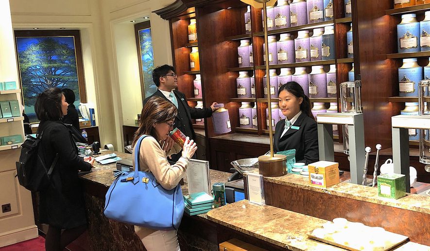 A customer sniffs tea at Fortnum & Mason in central London, a supplier of tea to Buckingham Palace, in this Sept. 14, 2018, photo. (Benjamin Plackett/Special to The Washington Times)