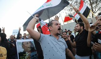 Demonstrators hold national flags and a poster with an image of a protester who was killed during previous demonstrations, demanding better public services and jobs, in the southern city of Basra, Iraq, Tuesday, Sept. 25, 2018. Masked gunmen shot dead Soad al-Ali, a human rights activist and mother of four, outside a supermarket in Basra on Tuesday, a brazen afternoon assassination that threatens to worsen tensions in the southern city wracked by violent protests. (AP Photo/Nabil al-Jurani) ** FILE **