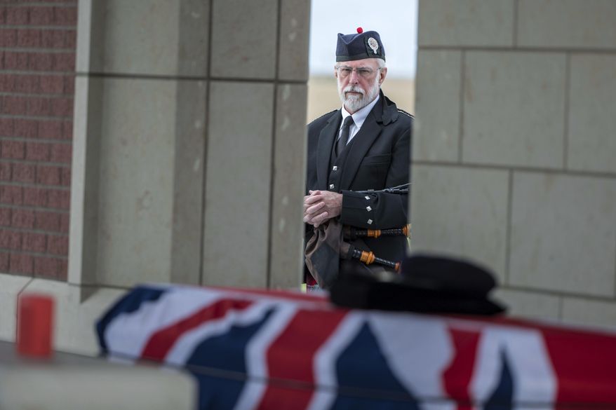 In this Monday, Sept. 24, 2018 photo, Bagpiper Malcolm WIlbur waits to play Amazing Grace for the funeral of Jean Watters at the Omaha National Cemetery in Omaha, Neb. Jean Watters was part of the super-secret team that broke the German ENIGMA code during World War II. (Chris Machian/Omaha World-Herald via AP)