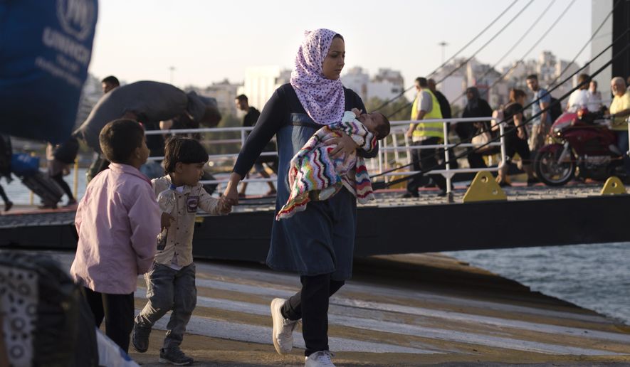 A Syrian woman with her children disembarks from a ferry, at the port of Piraeus, near Athens, Tuesday, Sept. 25, 2018. About 400 migrants and refugees arrived at the port from the island of Lesbos as authorities have been moving hundreds of migrants deemed to be vulnerable from the overcrowded Moria camp to camps on the mainland. (AP Photo/Petros Giannakouris)