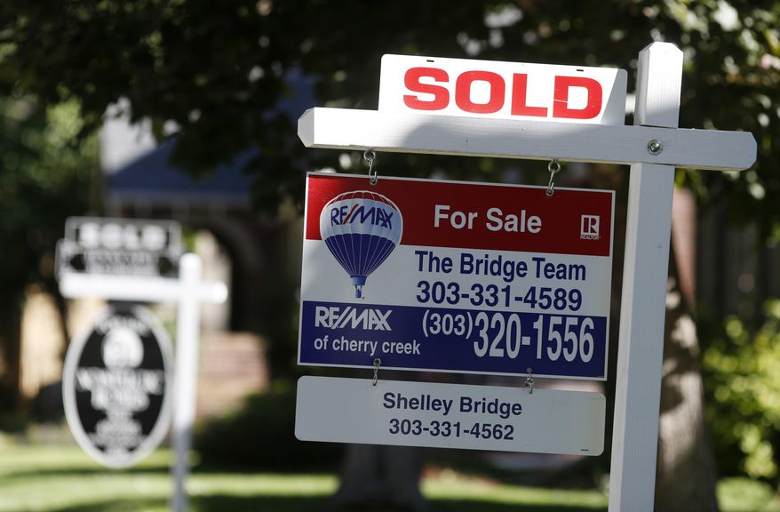 FILE- In this Aug. 30, 2018, file photo sold placards top sale signs outside homes on the market in Denver. On Tuesday, Sept. 25, the Standard & Poor's/Case-Shiller 20-city home price index for July is released. (AP Photo/David Zalubowski, File)