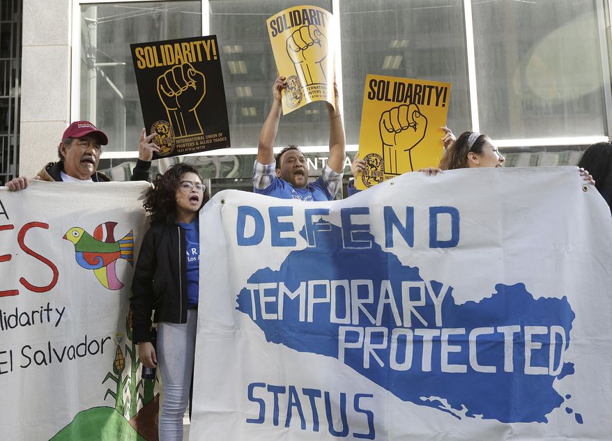 FILE - In this March 12, 2018 file photo, supporters of temporary protected status of immigrants cheer, hold signs and a banner with the outline of El Salvador at a rally at a federal courthouse in San Francisco, the day a lawsuit was filed against the Trump administration over its decision to end a program that lets immigrants live and work legally in the United States. During a hearing on Tuesday, Sept. 25, 2018, U.S. District Judge Edward Chen questioned the Trump administration's motives to end the program and repeated the president's vulgar language to describe some countries during a White House meeting in January. Chen is deciding whether to block the administration's decision to end temporary protected status for people from Sudan, Nicaragua, Haiti, and El Salvador. He did not immediately rule. (AP Photo/Jeff Chiu, File)