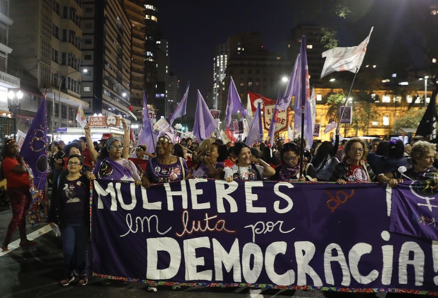 Women march to a campaign event with presidential candidate for the Workers Party, Fernando Haddad, in Sao Paulo, Brazil, Tuesday, Sept. 25, 2018. Brazil will hold general elections on Oct. 7. (AP Photo/Andre Penner)